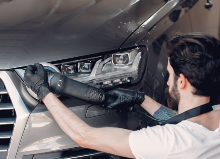a mechanic polishing a car after repair